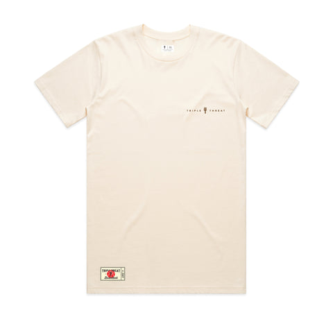 Cream T-shirt with small brown design of the Triple Threat logo in the middle of the text "Triple Threat" featuring a Triple Threat brand patch on the bottom corner