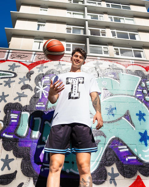 Model wearing triple threat basketball shorts and T-shirt with basketball