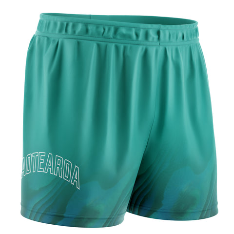 Teal basketball shorts with Paua design, featuring an elastic waistband, side pockets, and the text "Aotearoa" in white .